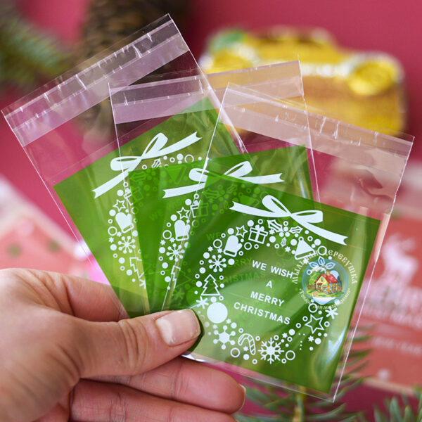 Целофановий міні пакетик “We wish a Merry Christmas/Різдвяний вінок” із зеленою підкладкою та з клейкою стрічкою, 7*7 cм + 3 см