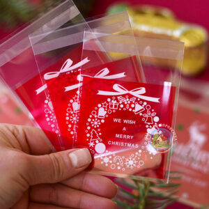 Целофановий міні пакетик “We wish a Merry Christmas/Різдвяний вінок” з червоною підкладкою та з клейкою стрічкою, 7*7 cм + 3 см